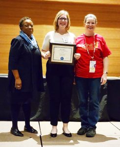 AIChE president, ISU chapter president and faculty mentor Stephanie Loveland on stage, recognized as Student Chapter of the Year at AIChE Annual Student Conference.