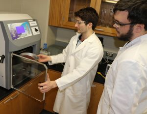 Two students using freeze-dryer in lab