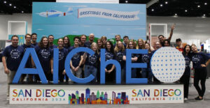 Students in the ISU AIChE chapter shown posting with the giant "AIChE" cutout letters and sign at the conference